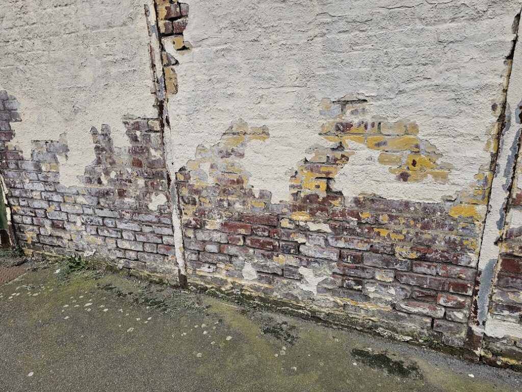 capillarité sur un mur avec des joints abimés et des briques humides, les enduits tombent à cause de l'humidité