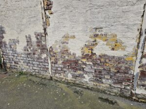 capillarité sur un mur avec des joints abimés et des briques humides, les enduits tombent à cause de l'humidité