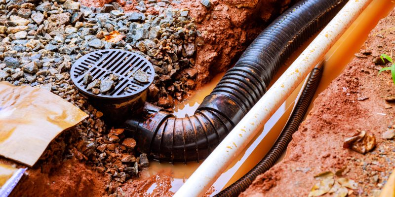 système de drainage dans une cave avec un puisard, une pompe de relevage pour évacuer l'eau et un réseau de tuyaux perforés recouverts de gravier pour prévenir les infiltrations d'humidité. Ce système assure l'évacuation rapide de l'eau vers l'extérieur, protégeant les fondations de la maison contre les dégâts liés à l'humidité et maintenant l'intérieur de la cave sec.