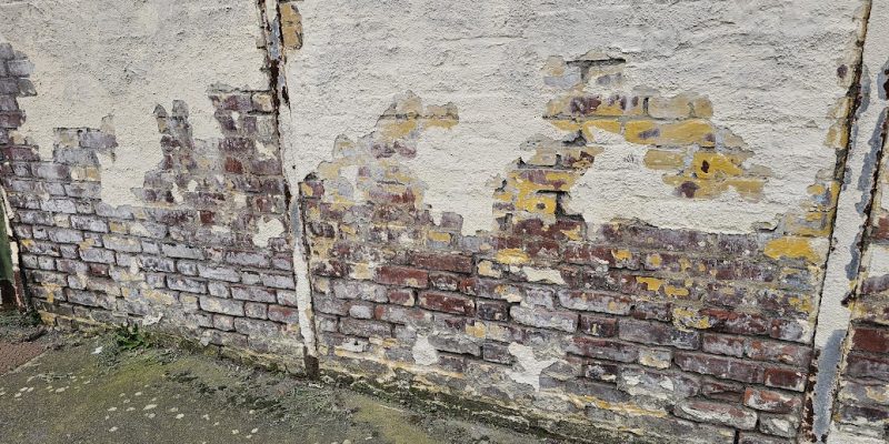 capillarité sur un mur avec des joints abimés et des briques humides, les enduits tombent à cause de l'humidité